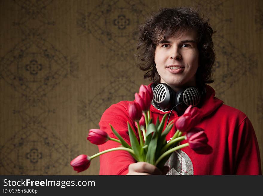 An image of a young man with red flowers. An image of a young man with red flowers