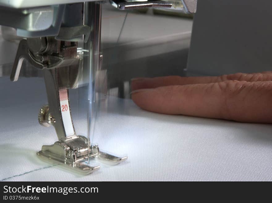 A woman sewing with the blurred motion of the needle