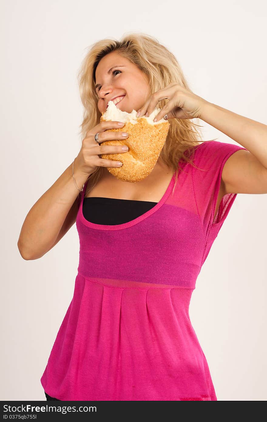 Beautiful brunette girl eating a bread isolated on the white background. Beautiful brunette girl eating a bread isolated on the white background