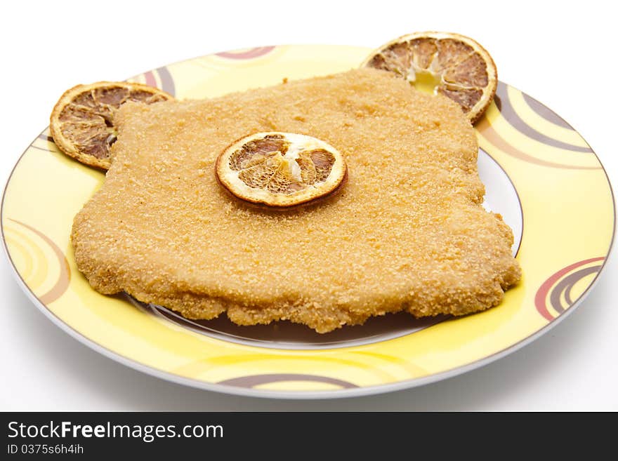 Escalope raw and breaded with lemon onto plates. Escalope raw and breaded with lemon onto plates