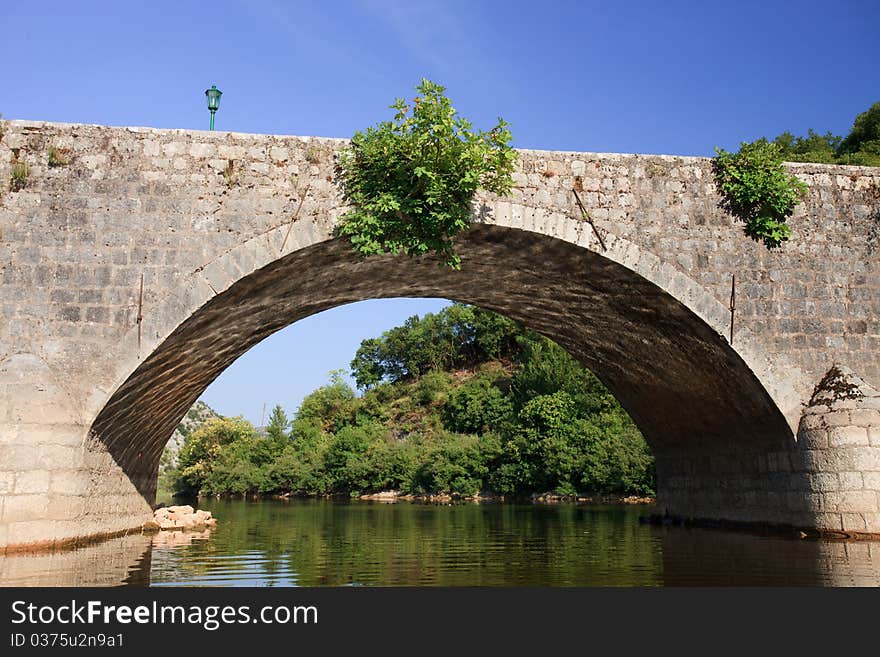 Archway made of stone over a slow flowing river. Archway made of stone over a slow flowing river