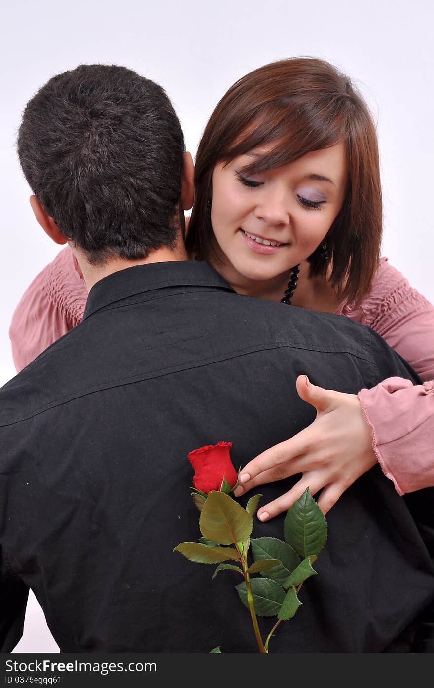 Happy beautiful teenage couple, a boy giving a rose to his girlfriend