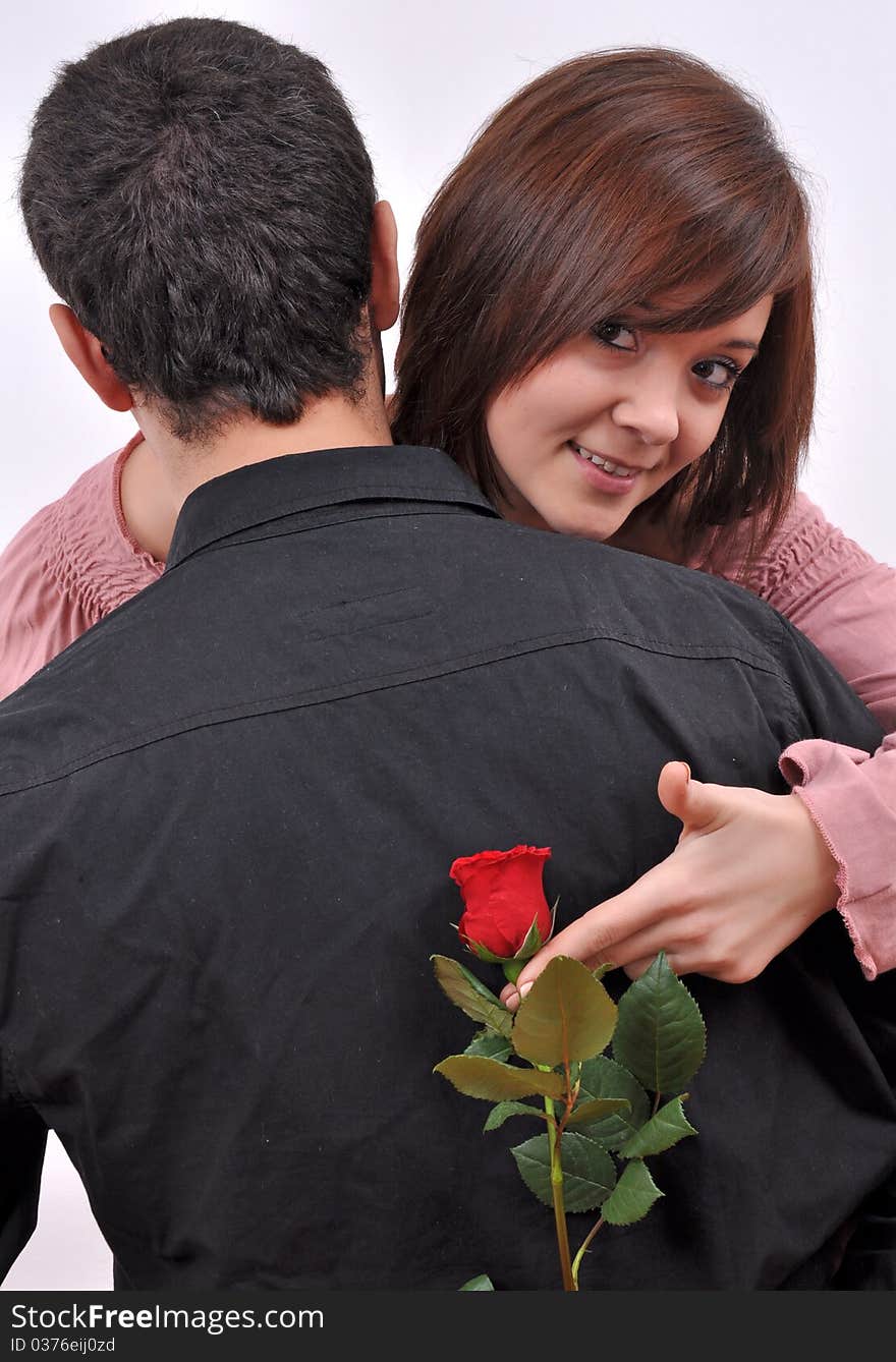 Happy beautiful teenage couple, a boy giving a rose to his girlfriend