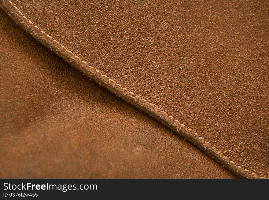 Seam on a brown pressed leather bag