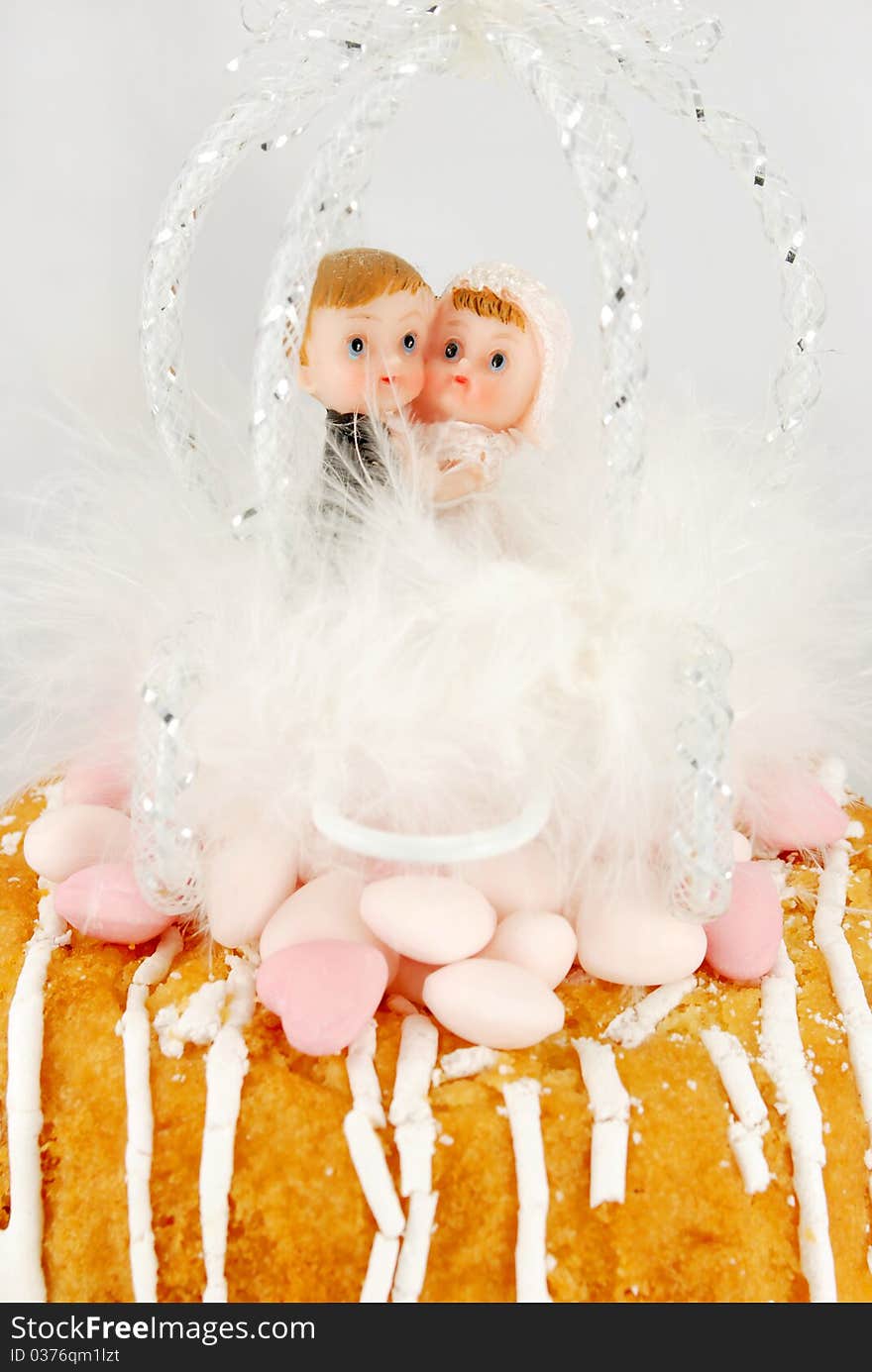 Children bride and groom figurines in a feather carriage. Children bride and groom figurines in a feather carriage