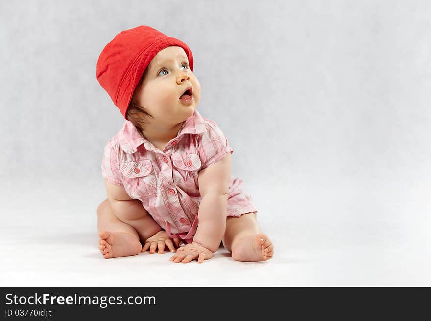 Sweet baby girl in red cap - studio shot