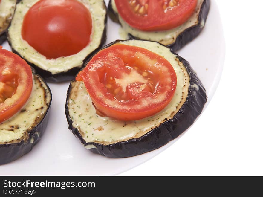 Fried eggplant with tomatoes and garlick sauce on a white background