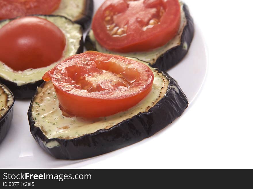 Fried eggplant with tomatoes and garlick sauce on a white background