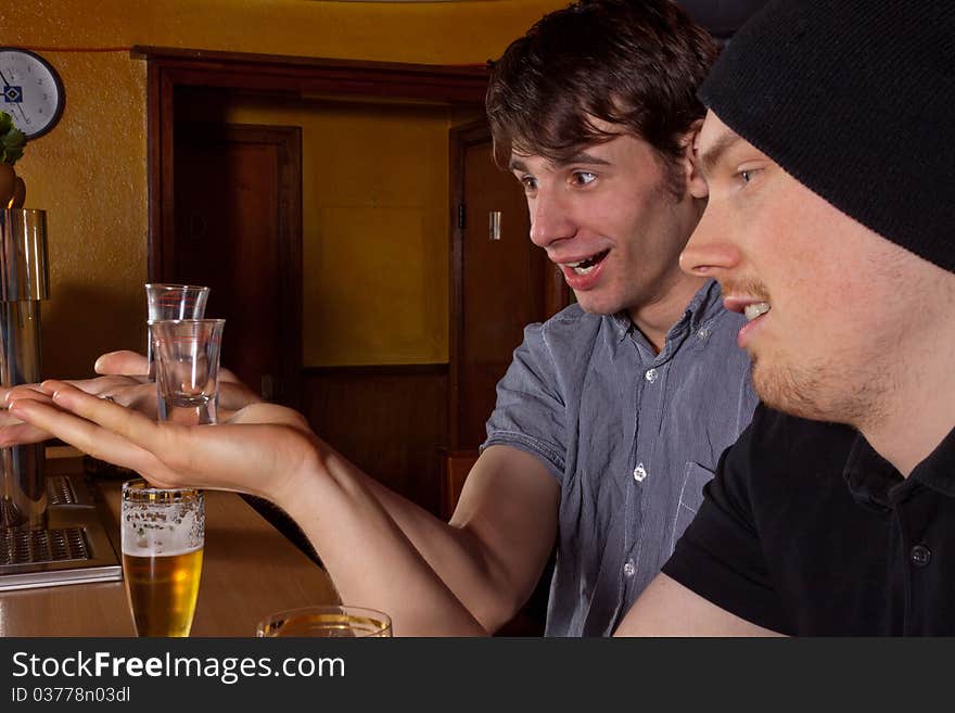 Two friends sitting in a pub and drinking hard liquor. Two friends sitting in a pub and drinking hard liquor