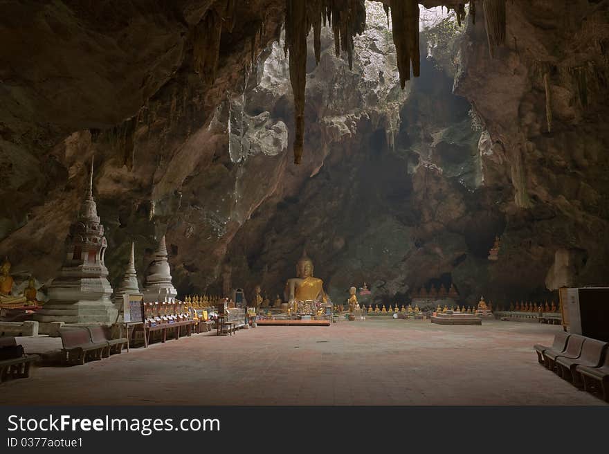 Image of buddha in the cave that the light shine through. Picture is public temple in cave at Phetchaburi province,Thailand. Image of buddha in the cave that the light shine through. Picture is public temple in cave at Phetchaburi province,Thailand.