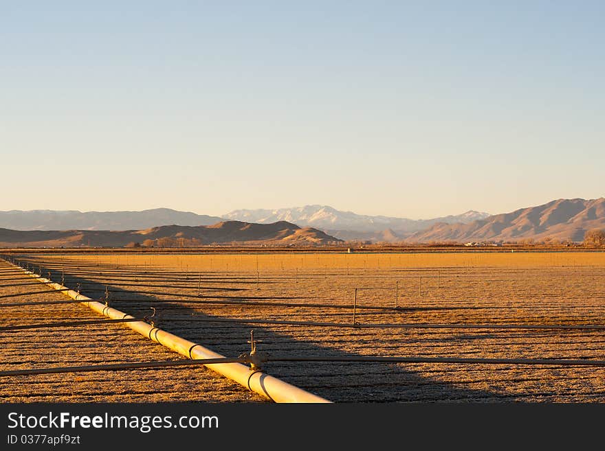 A beautiful landscape of a farm field. It shows the irrigation on the farm and the nice mountains in the background. A beautiful landscape of a farm field. It shows the irrigation on the farm and the nice mountains in the background.