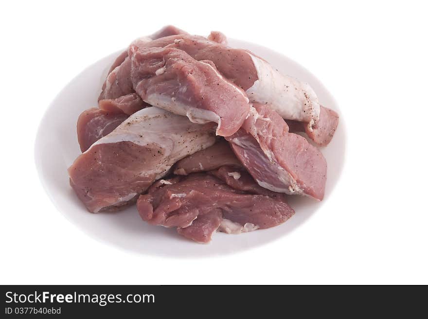 Crude meat on a plate on a white background