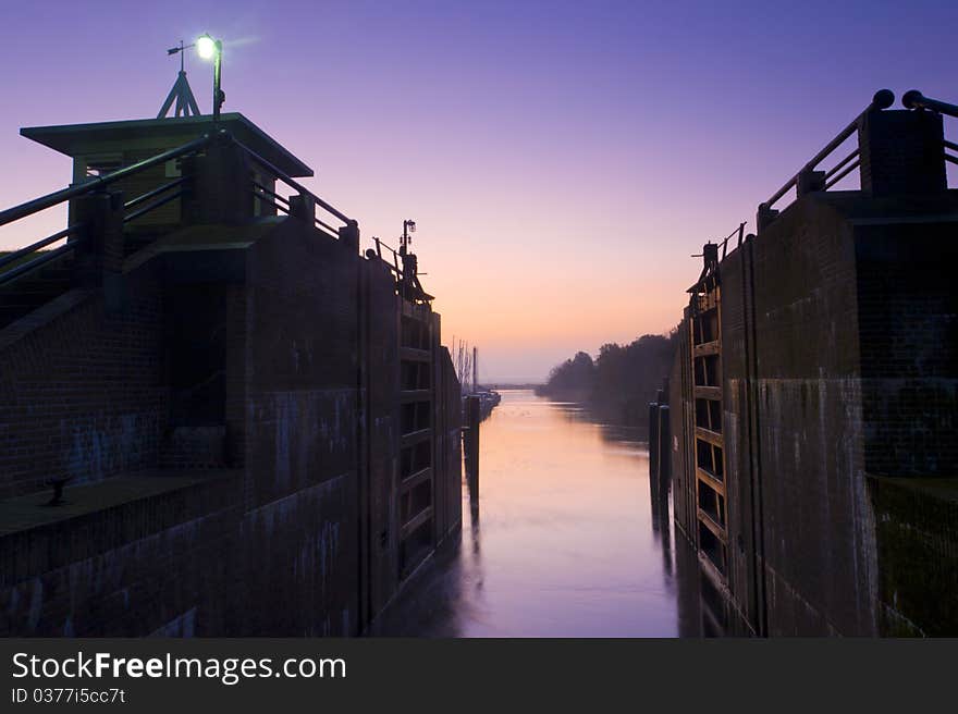 A sluice at a beautiful tranquil morning with warm light on the lock gates. A sluice at a beautiful tranquil morning with warm light on the lock gates.