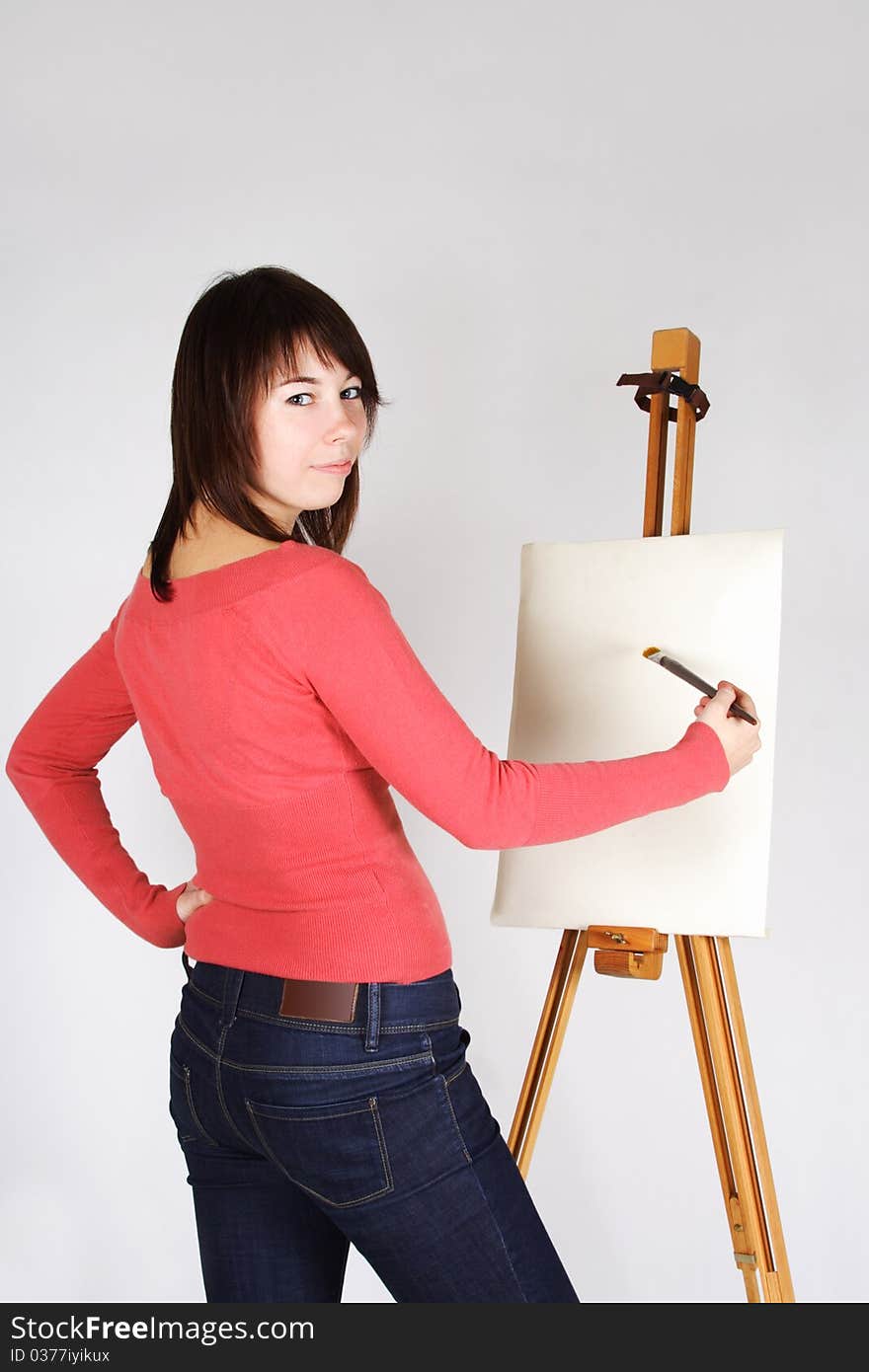 Girl standing near easel and painting