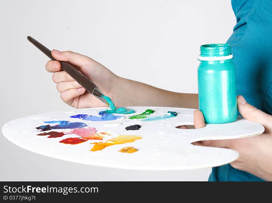 Closeup of woman mixing paint on palette