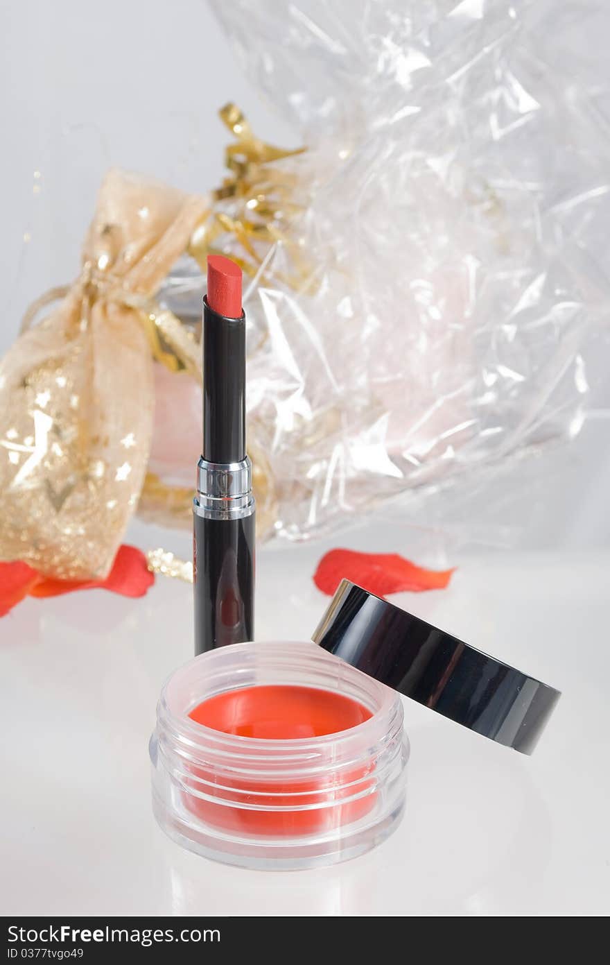 Red lipstick and blush, gift packing on a background.