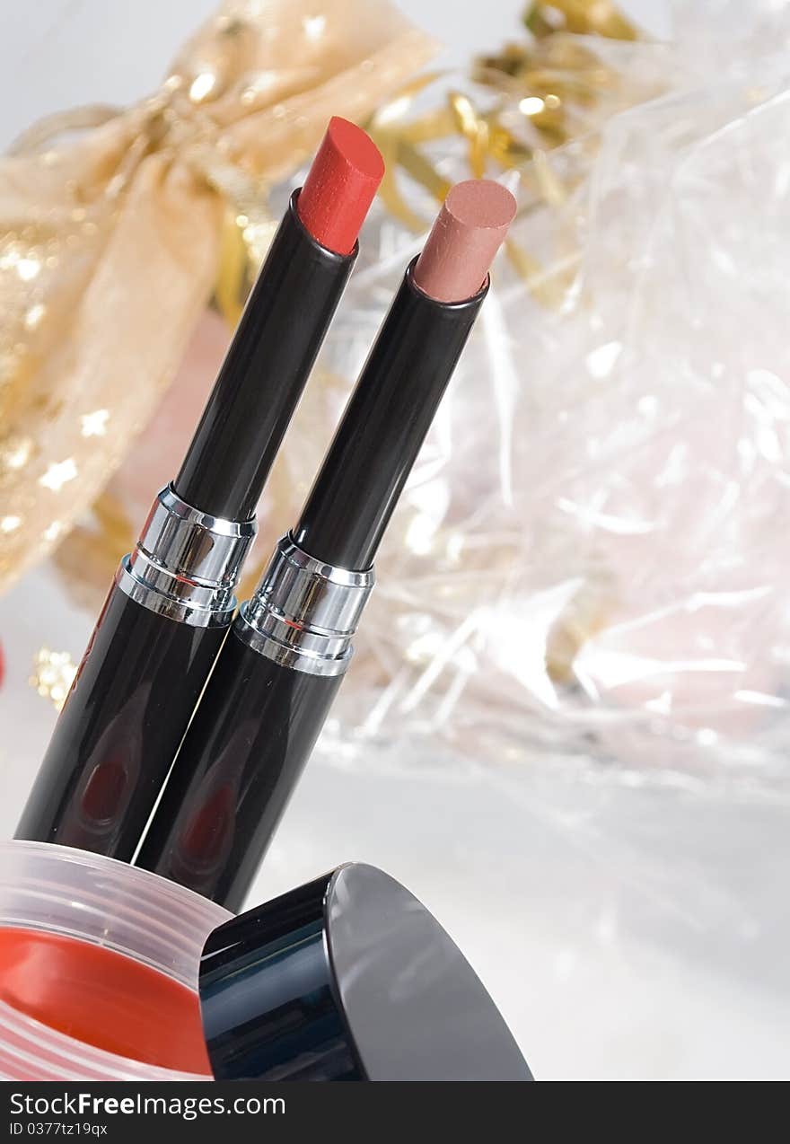 Red lipstick and blush, gift packing on a background.