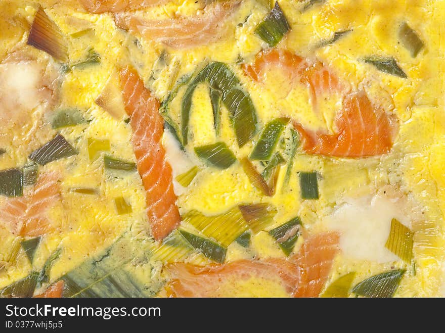 Colorful baked salmon quiche closeup.