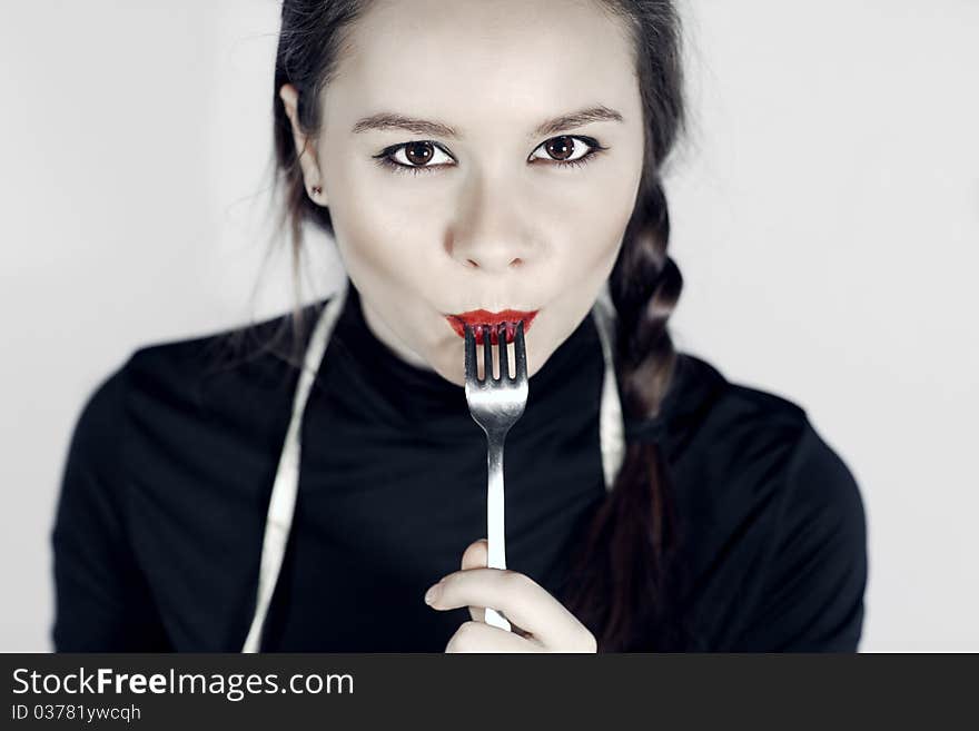 Close up of woman mouth  keeping a fork near the lips. Close up of woman mouth  keeping a fork near the lips