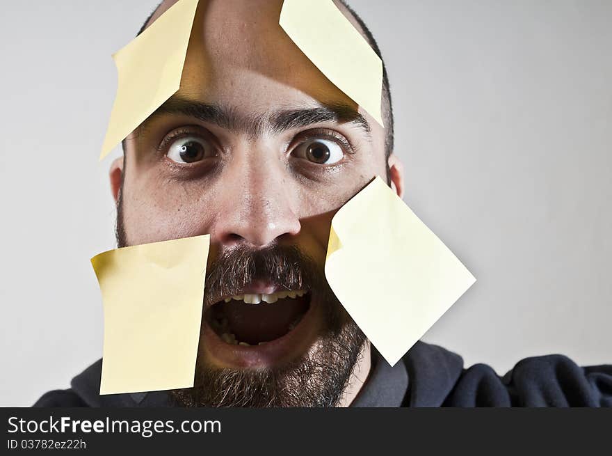 Disparate man with postit on his face on white background