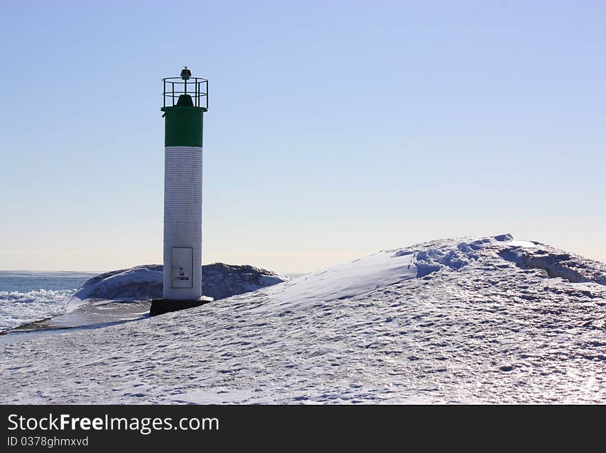 Frozen Beach with Lighthouse on a snowy pier. Frozen Beach with Lighthouse on a snowy pier.