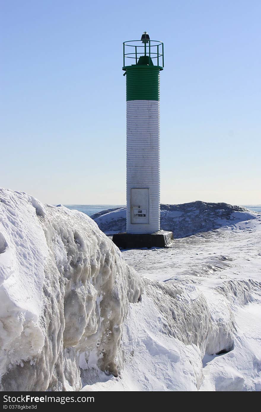 Green and white lighthouse in winter. Green and white lighthouse in winter