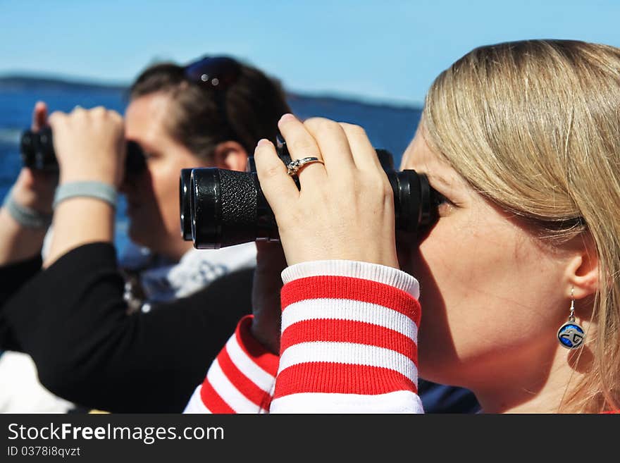 Young woman looking through binoculars. Young woman looking through binoculars