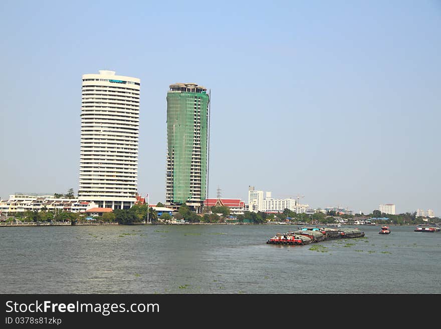 Construction and completed building on the river bank.