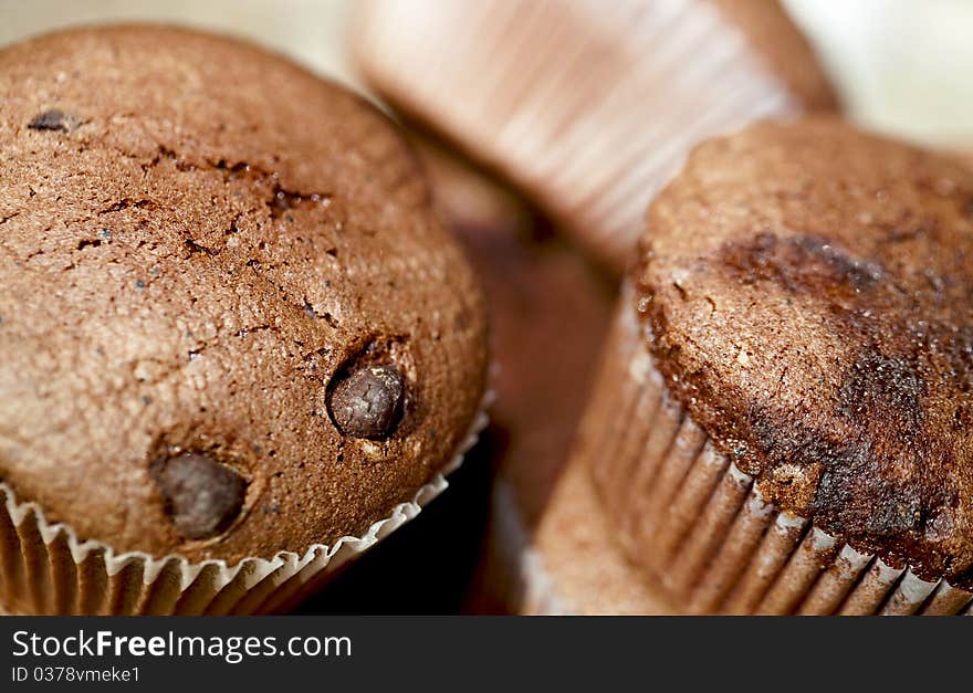 Chocolfte cake as background. Muffins