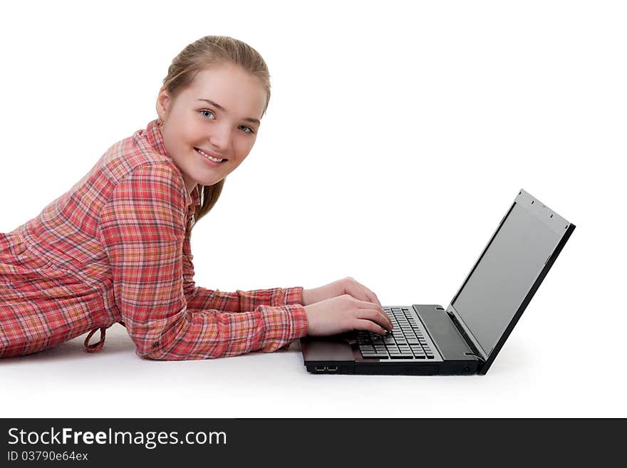 Beautiful young girl lying on the floor with laptop