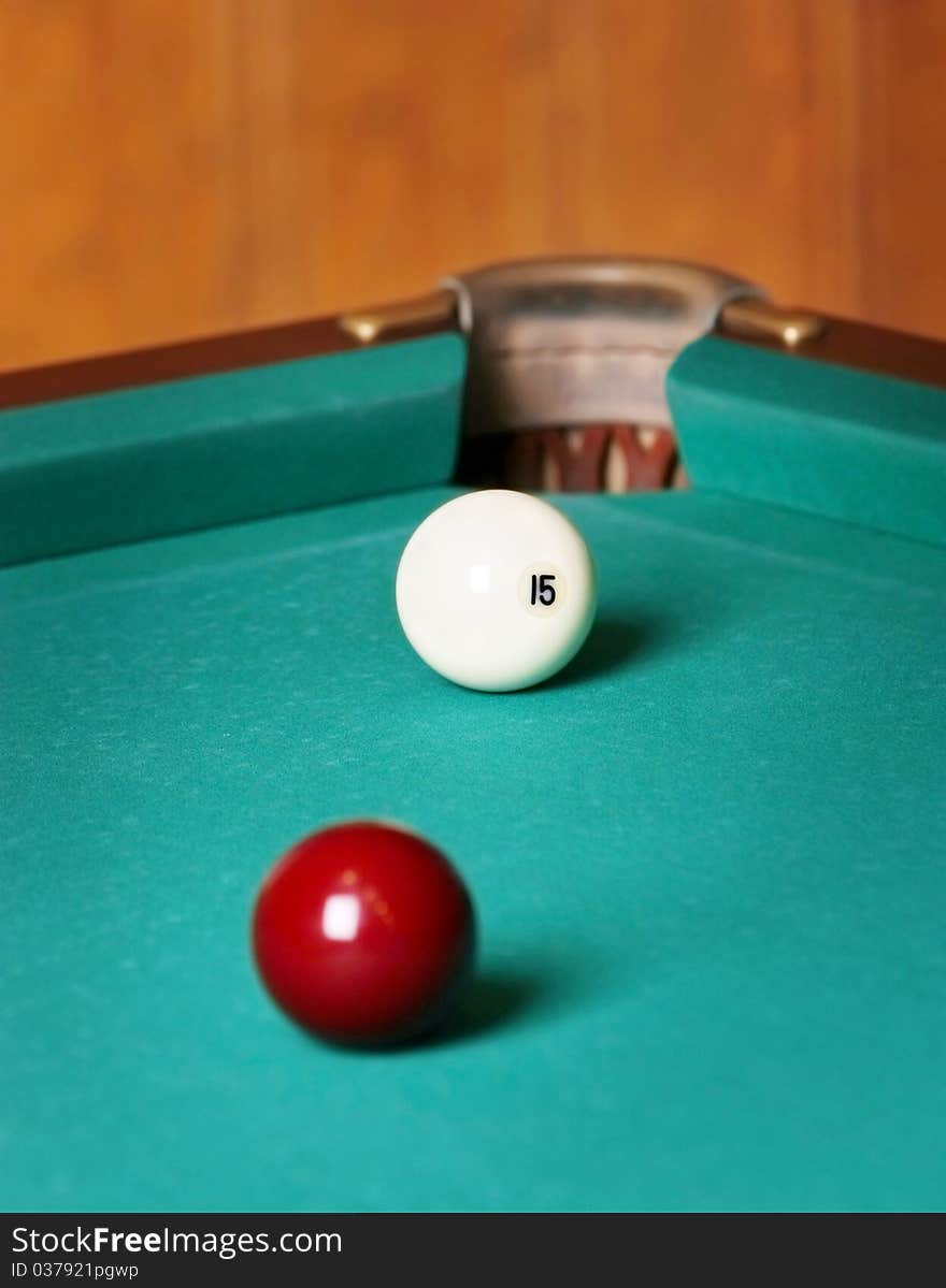 Two billiard spheres stand opposite to a billiard pocket