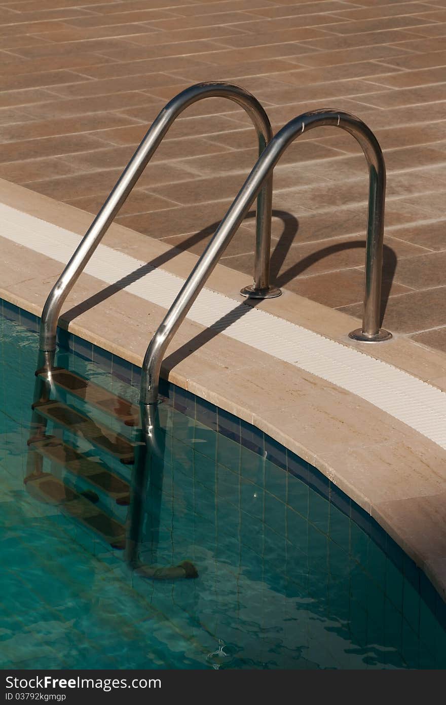 Steel staircase from the pool with turquoise water