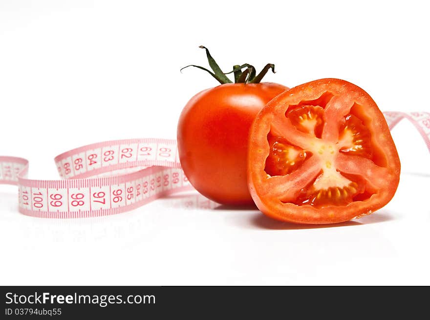 Fresh tomato and tape measure isolated ver white