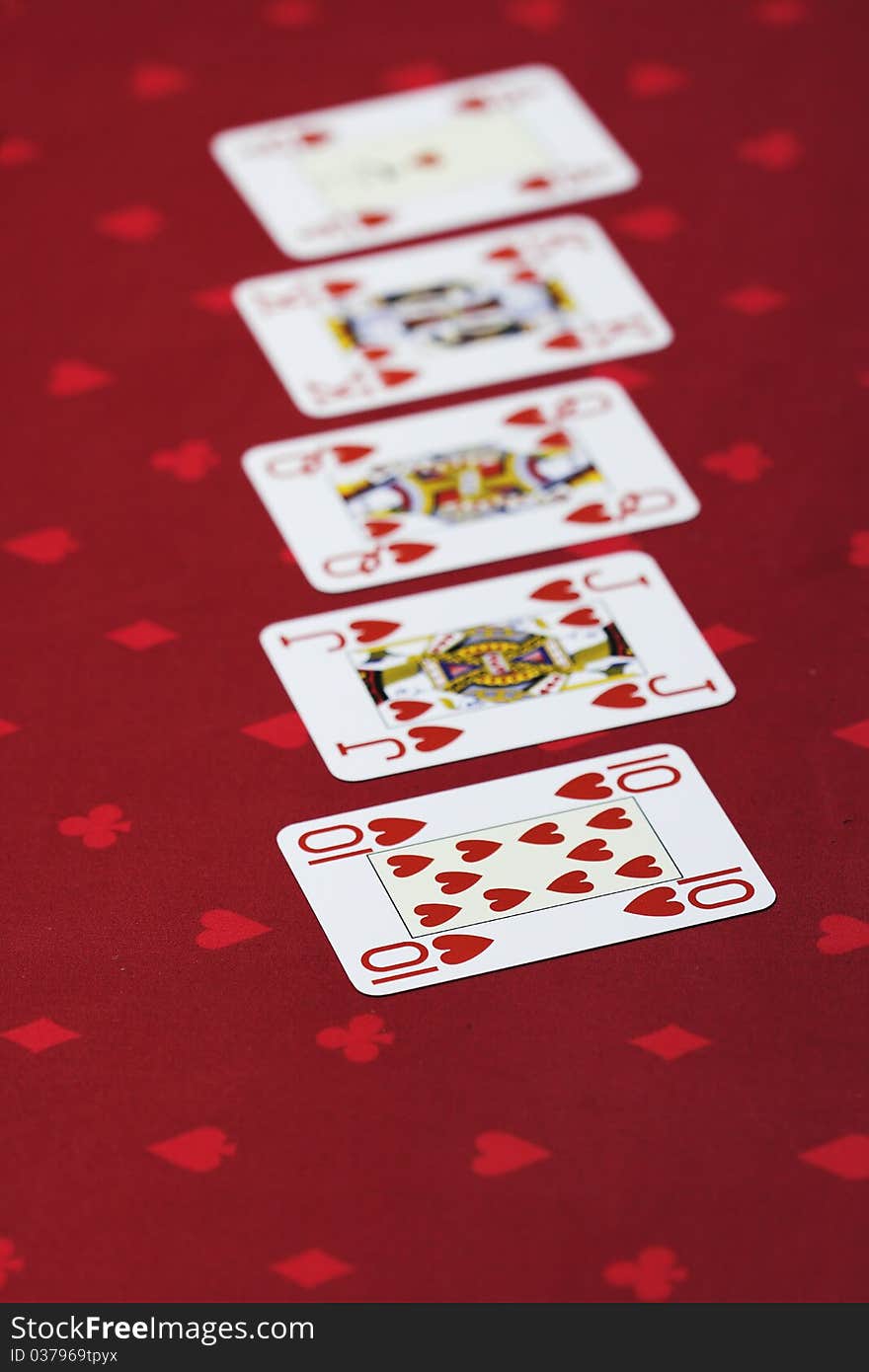 Flush of hearts - Set of 4 official playing poker cards on the casino table