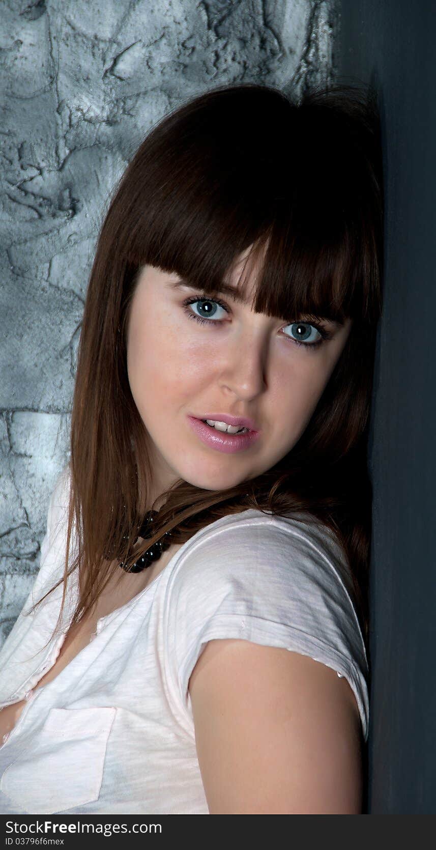 Portrait of the girl in a white blouse on a gray background