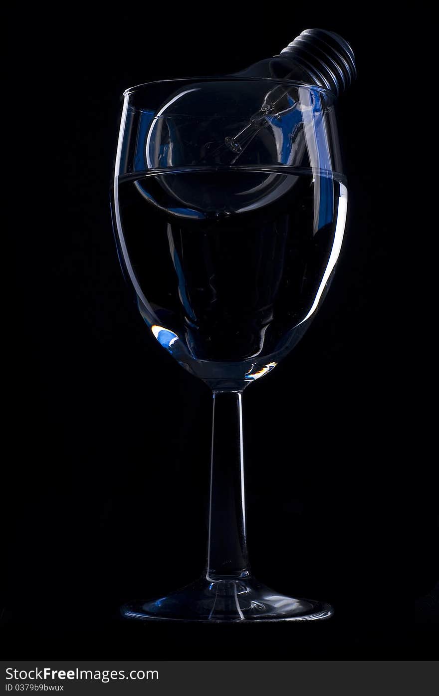 Wine glass and light bulb over black