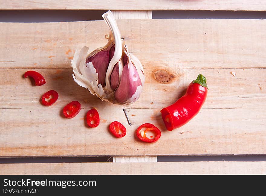 Garlic and red hot chili pepper on wooden desk. Garlic and red hot chili pepper on wooden desk