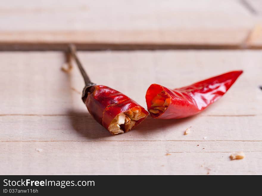 Breaking red hot chili pepper on the wooden desk