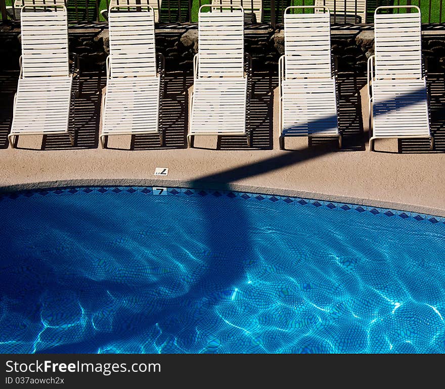 Empty beach chairs sitting by the pool