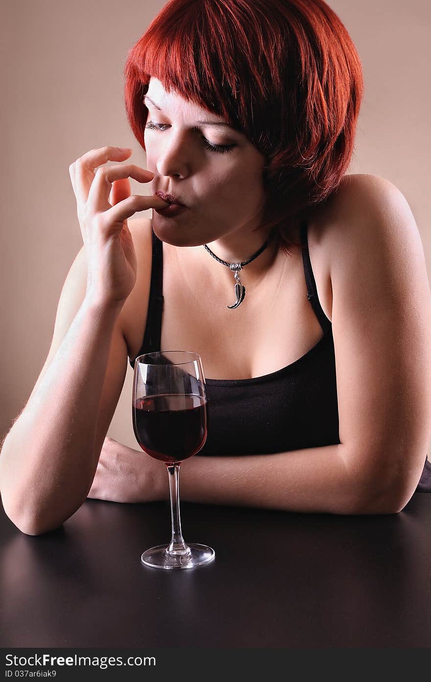 Girl c a red wine glass on a dark grey background