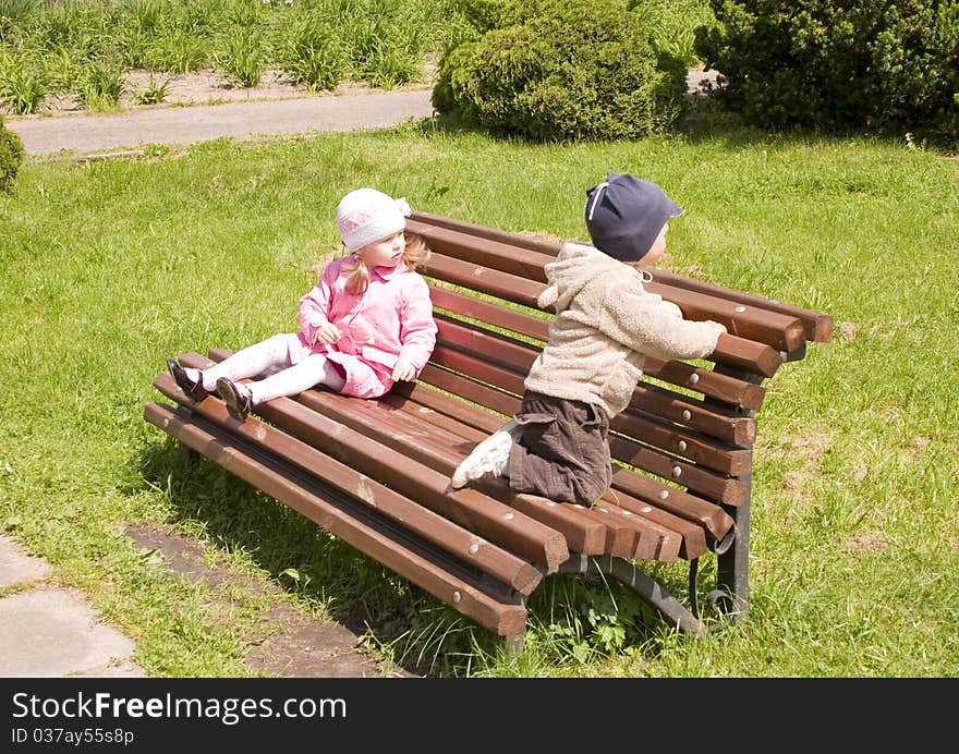 Little boy and girl in park on a bench