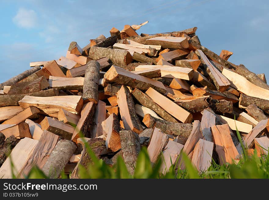 Pile of chopped fire wood on blue sky background. Pile of chopped fire wood on blue sky background