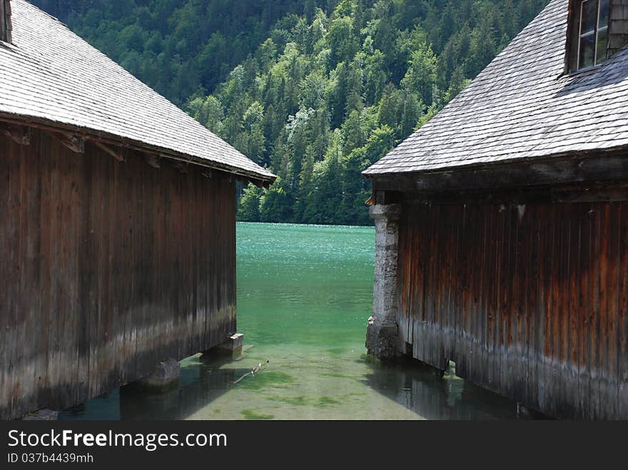 A lake with two boat garage an a forest in the background. A lake with two boat garage an a forest in the background