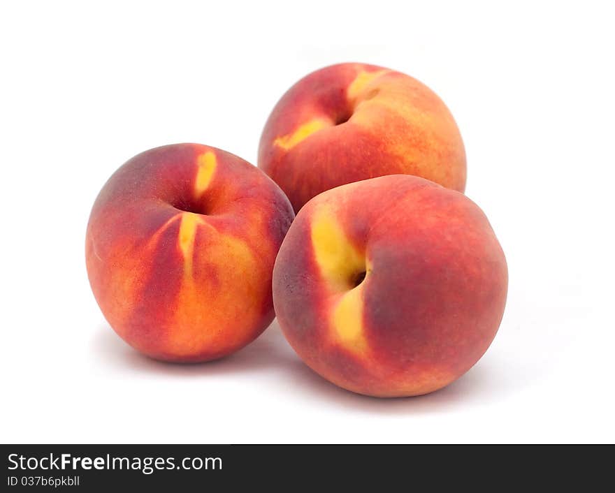 Three orange red peaches  on a white background.