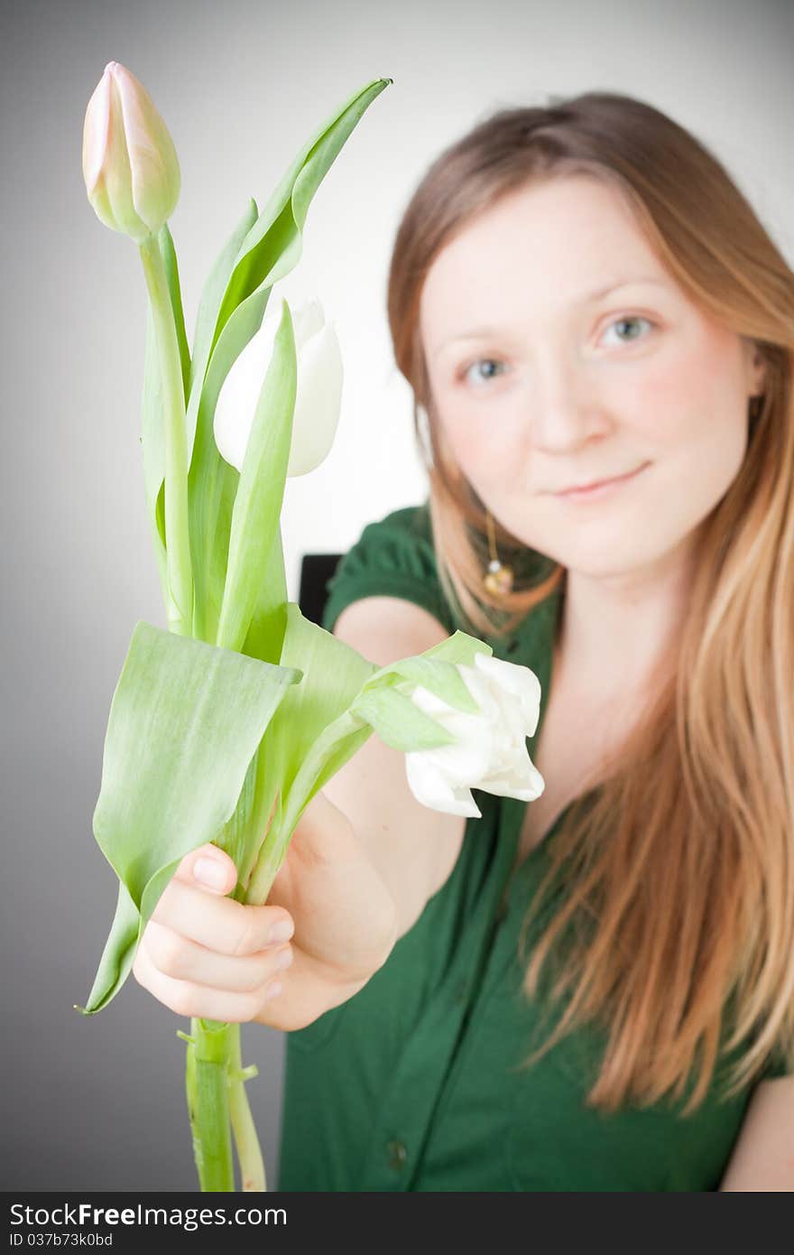 Young girl with tulips, with grey background. Young girl with tulips, with grey background