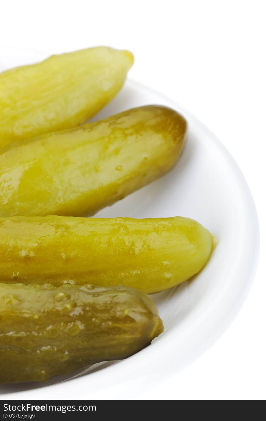 Some pickled cucumbers in white plate isolated