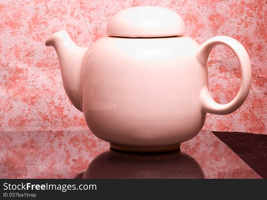 White ceramic teapot on reflexive medium