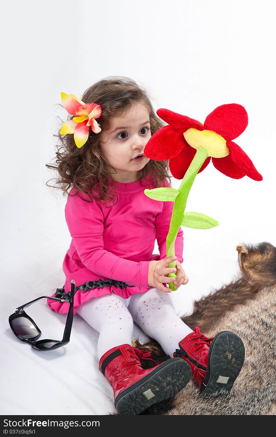 The two-year girl with expressive eyes in a pink dress. The two-year girl with expressive eyes in a pink dress.