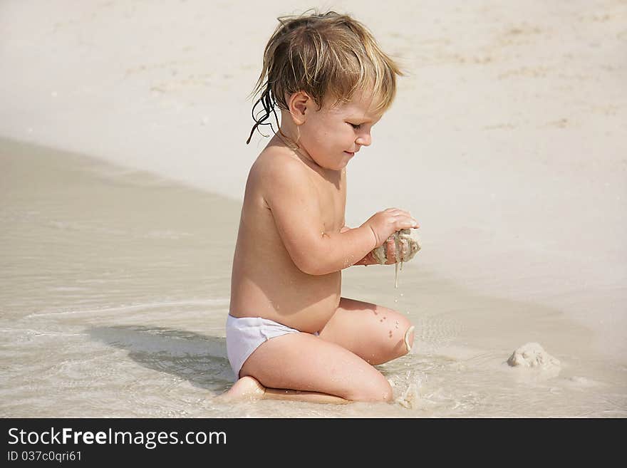 Cute child playing with sand on beach. Cute child playing with sand on beach