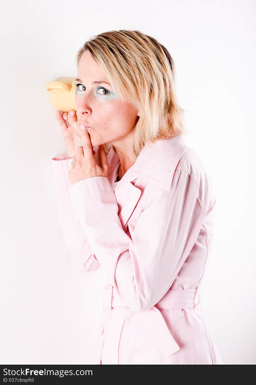 Woman listening through the wall with the cup